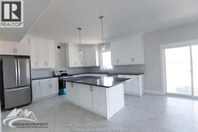 Chatham apartment for rent - A kitchen with white cabinets and a black countertop.