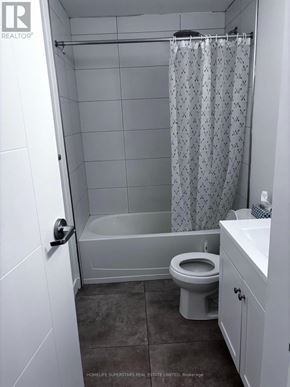 Waterloo townhouse for rent - A white bathroom with a toilet, sink, and shower.