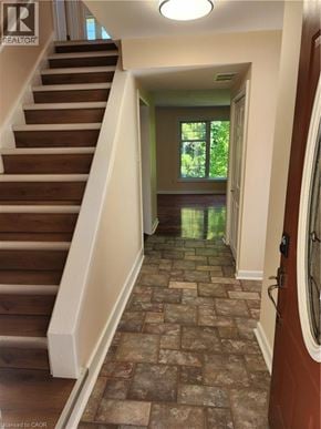Ancaster apartment for rent - A hallway with a staircase and a tiled floor.