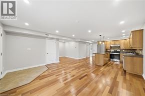 Paris condo for rent - A spacious room with wooden flooring and a kitchen area.