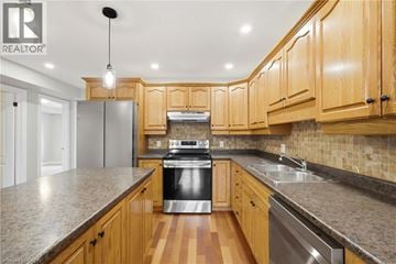 Paris condo for rent - A kitchen with wooden cabinets and a granite countertop.