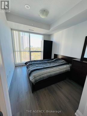 Toronto (Parkwoods-Donalda) condo for rent - A bedroom with a bed, dresser, and window.