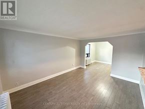 Toronto (Birchcliffe-Cliffside) apartment for rent - A spacious room with wooden flooring and white walls.