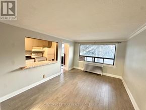 Toronto (Birchcliffe-Cliffside) apartment for rent - A spacious room with wood flooring and a window overlooking a snowy landscape.
