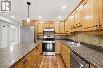 Brant (Paris) condo for rent - A kitchen with wooden cabinets and granite countertops.
