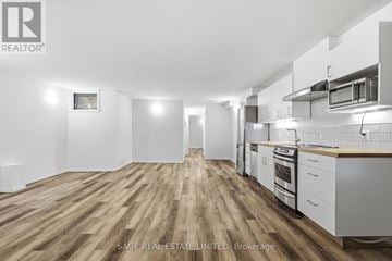 Toronto (Niagara) townhouse for rent - A spacious kitchen with white cabinets and a wooden floor.