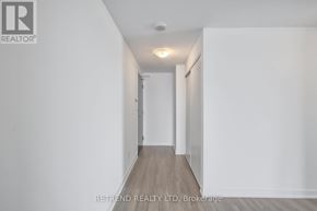 Kitchener condo for rent - A long, narrow hallway with white walls and wooden flooring.