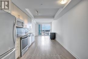 Kitchener condo for rent - A modern kitchen with stainless steel appliances and a wooden floor.