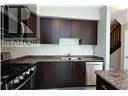 Hamilton (Carpenter) townhouse for rent - A modern kitchen with dark brown cabinets and a stove top oven.