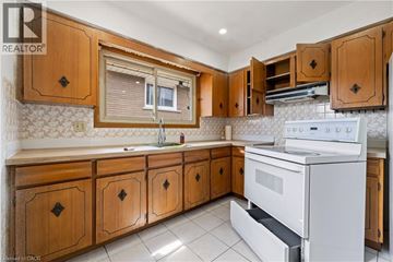 Hamilton apartment for rent - A kitchen with wooden cabinets and a white stove top oven.