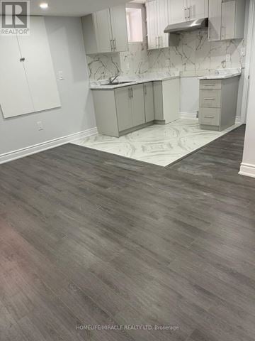 Brampton (Northwest Brampton) apartment for rent - A kitchen with white cabinets and a marble backsplash.