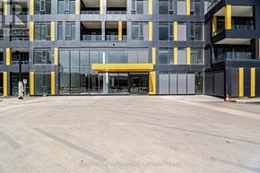 Burlington (Alton) condo for rent - A large building with a yellow and black entrance.