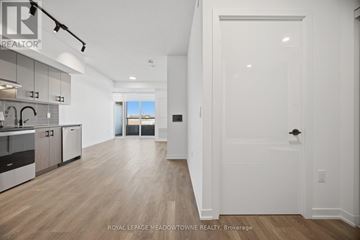 Burlington (Alton) condo for rent - A spacious kitchen with white cabinets and a large island.