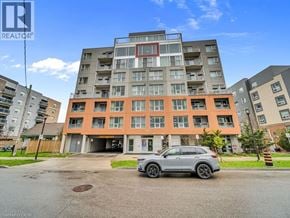 Waterloo condo for rent - A grey car is parked in front of a multi-story apartment building.