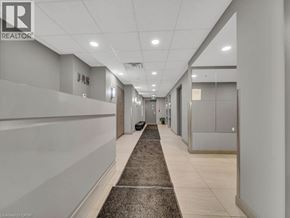 Waterloo condo for rent - A hallway with a carpeted area in the middle and a door at the end.