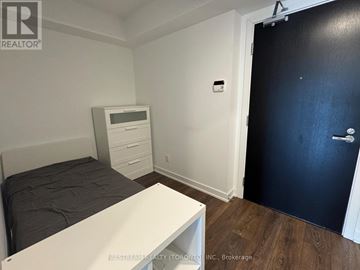 Toronto (Church-Yonge Corridor) condo for rent - A modern living room with a glass table and a black leather sofa.
