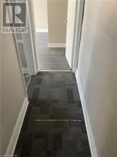 Niagara Falls (Downtown) multi-family for rent - A hallway with a black tiled floor and white walls.