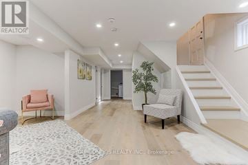 Toronto (Parkwoods-Donalda) apartment for rent - A living room with a pink chair and a grey chair with a plant between them.