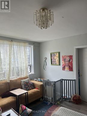 Ajax (Central West) multi-family for rent - A living room with a tan couch and a chandelier.