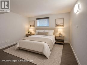 Burnaby apartment for rent - A bedroom with a large bed and two nightstands.