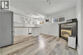 Kitchener apartment for rent - A spacious kitchen with a refrigerator, cabinets, and a fireplace.