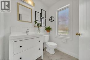 Kitchener apartment for rent - A white bathroom with a sink, toilet, and a window.