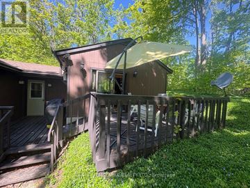 Oro-Medonte (Sugarbush) apartment for rent - A wooden deck with a white umbrella is in front of a house.