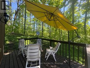 Oro-Medonte (Sugarbush) apartment for rent - A yellow umbrella is open on a deck with two chairs.