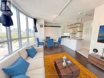 Toronto (Willowdale East) condo for rent - A living room with a white couch and blue pillows.