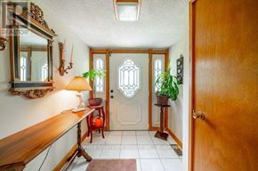 Whitchurch-Stouffville apartment for rent - A hallway with a wooden door and a mirror on the wall.
