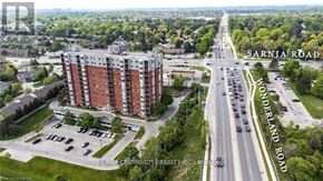 London North (North I) condo for rent - A street view of Sarnia Road and Wonderland Road with a multi-story building on the left.