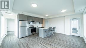 Waterloo condo for rent - A modern kitchen with a refrigerator, microwave, and oven.