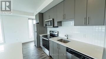 Waterloo condo for rent - A modern kitchen with a stainless steel oven and microwave.