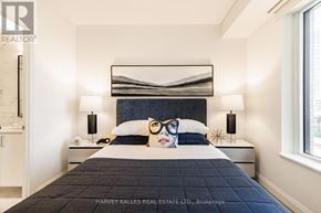 Toronto (Mount Pleasant West) condo for rent - A bedroom with a large bed and a painting of a woman's face on the pillow.