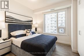 Toronto (Mount Pleasant West) condo for rent - A bedroom with a large bed and a window overlooking a cityscape.