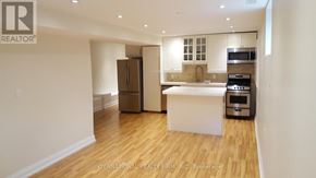 Toronto (Yonge-St. Clair) triplex for rent - A kitchen area with a refrigerator, microwave, oven, and sink.