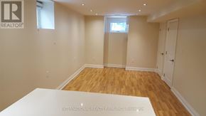 Toronto (Yonge-St. Clair) triplex for rent - A room with wooden flooring and white walls, with a window and a door visible.