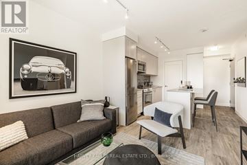 Toronto (Mount Pleasant West) condo for rent - A living room with a grey couch and a framed picture of a car on the wall.