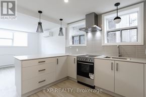 Toronto (East End-Danforth) triplex for rent - A modern kitchen with white cabinets and a stainless steel oven.