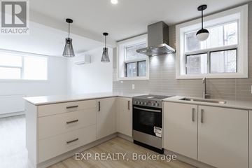 Toronto (East End-Danforth) triplex for rent - A modern kitchen with white cabinets and a stainless steel oven.