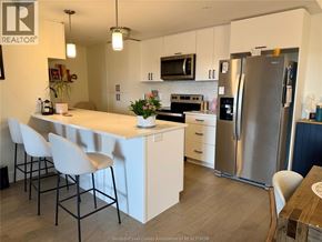 Lasalle condo for rent - A kitchen with white cabinets and a stainless steel refrigerator.