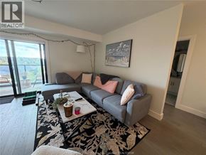 Lasalle condo for rent - A living room with a grey couch and a coffee table in front of a window.