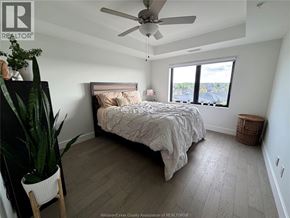 Lasalle condo for rent - A bedroom with a bed, a plant, and a window.