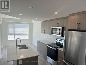 Barrie (Little Lake) condo for rent - A kitchen with a sink, stove, and refrigerator.