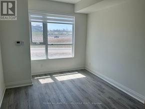 Barrie (Little Lake) condo for rent - A room with a large window and a view of a parking lot.
