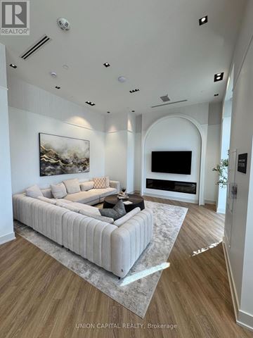 Burlington (Brant) condo for rent - A modern living room with a large couch and a painting on the wall.