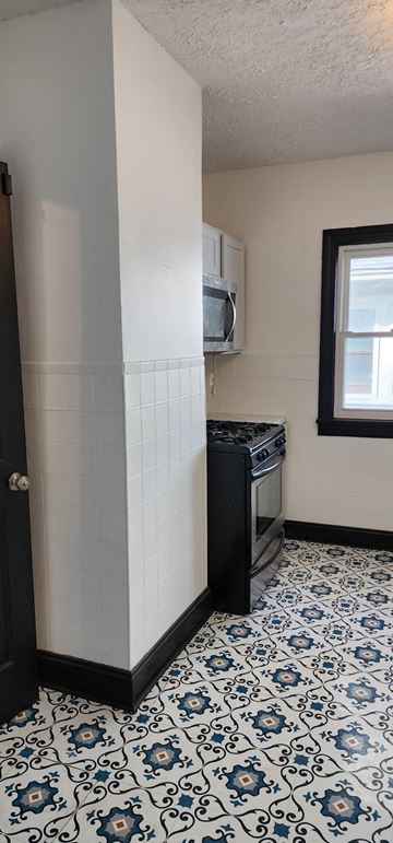 Cleveland apartment for rent - A kitchen with a black oven and a tiled floor.