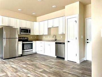 Missoula apartment for rent - A kitchen with white cabinets and a wooden floor.