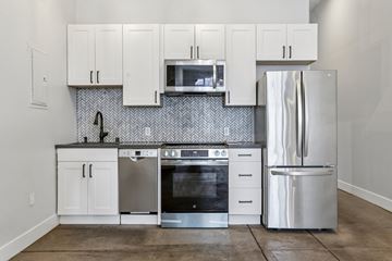 Oakland apartment for rent - A kitchen with white cabinets and a silver refrigerator.