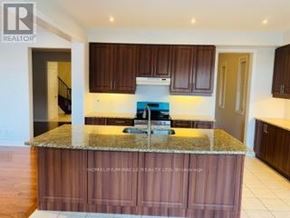 Brampton (Credit Valley) apartment for rent - A kitchen with brown cabinets and a granite countertop.